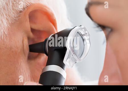 Close-up of Female Doctor Examining Patient's Ear avec Otoscope Banque D'Images