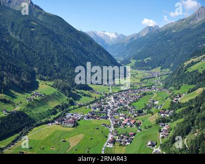 VUE AÉRIENNE. La vallée du Stubai avec Neustift im Stubaital et, au loin, le Zuckerhütl (3507m) et le glacier Sulzenauferner. Tyrol, Autriche. Banque D'Images