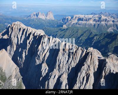 VUE AÉRIENNE. Côté sud de la Marmolada (3343m) avec, au loin, le Groupe de Sassolungo (à gauche) et le Groupe de Sella (à droite). Dolomites, Italie. Banque D'Images