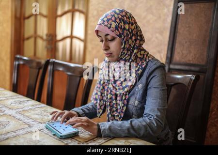 Israa Al-ashqar, étudiante palestinienne, 23 ans, travaille sur une application sur son téléphone portable, à l'intérieur de sa maison dans la ville de Gaza le 14 février 2016. Al-ashqar et trois de ses collègues ont inventé une version améliorée de l'application Braille Touch pour la lecture et l'écriture pour les aveugles, et il s appelle (Brill Board). Avec cette application, les personnes aveugles peuvent écrire sur une application qui veut un téléphone intelligent, que ce soit dans les sites de réseaux sociaux ou des messages. ) MIDEAST-GAZA-APPLICATION-FOR-BLIND WissamxNassar PUBLICATIONxNOTxINxCHN PALESTINIAN College Student Israa Al Ashqar 23 travaille SUR l'application ON Banque D'Images