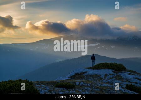 Homme au coucher du soleil sur la montagne Banque D'Images