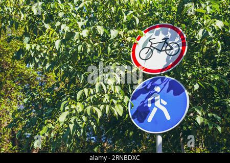 Les panneaux de signalisation cyclable sont interdits et la circulation piétonne est autorisée monté sur un poteau. Sur fond d'arbres verts Banque D'Images