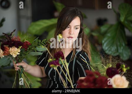 Woman putting together bouquet of flowers Stock Photo