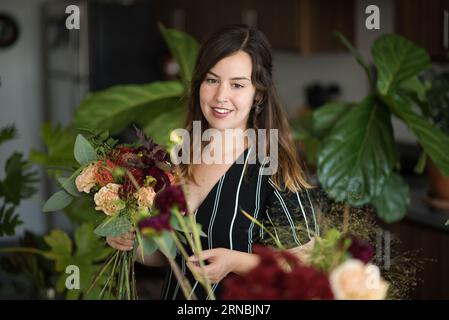 Femme assemblant bouquet de fleurs Banque D'Images