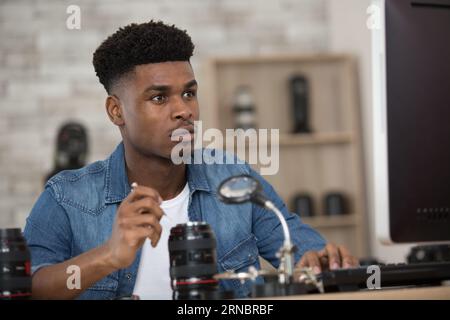 man repairing photo camera optical dslr lens Stock Photo