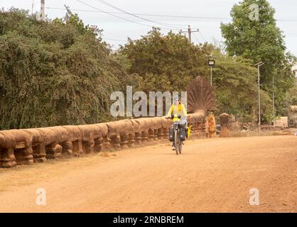 Femme voyageur sur son vélo chargé de sacs passant par t Banque D'Images