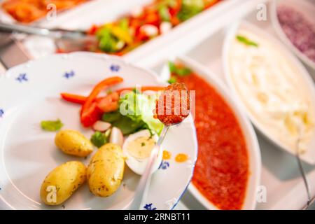 Un client du restaurant met un délicieux caviar rouge fumé sur une assiette. Déjeuner buffet de fruits de mer dans un café en Finlande Banque D'Images