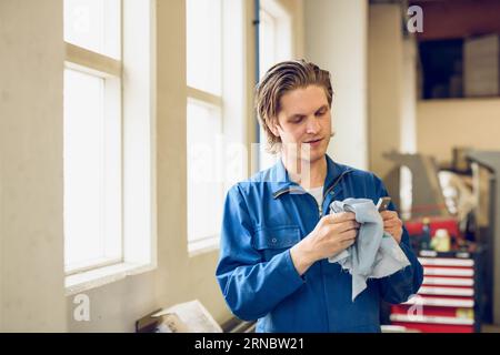 Man on factory wiping detail Stock Photo