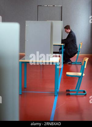 (160313) -- MAINZ, March 13, 2016 -- A man fills in his ballot at a polling station in Mainz, Germany, March 13, 2016. State elections in three German states: Rhineland-Palatinate, Saxony-Anhalt and Baden-Wuerttemberg, is held on Sunday, which is a crucial test-case for German Chancellor and Chairwoman of the German Christian Democrats (CDU) Angela Merkel, who has come under increasing pressure over her immigration policy towards migrants and refugees. Germany s anti-migration party, the Alternative for Germany has solid polling numbers and will almost certainly win seats in all three state pa Banque D'Images