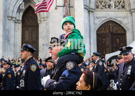 (160317) -- NEW YORK, le 17 mars 2016 -- Un garçon est assis sur les épaules d'un officier de la police de New York pendant le St. Patrick s Day Parade à New York, aux États-Unis, le 17 mars 2016. Des centaines de milliers de personnes se sont rassemblées le long de la Cinquième Avenue de New York pour observer la rue Patrick s Day Parade ici jeudi. ) ÉTATS-UNIS-NEW YORK-ST. PATRICK S DAY-PARADE LixChangxiang PUBLICATIONxNOTxINxCHN New York Mars 17 2016 un garçon est assis SUR les épaules de l'officier de NYPD pendant la St Patrick S Day Parade à New York aux États-Unis LE 17 2016 Mars des centaines de milliers de célébrités se sont rassemblées aux côtés de New York Banque D'Images