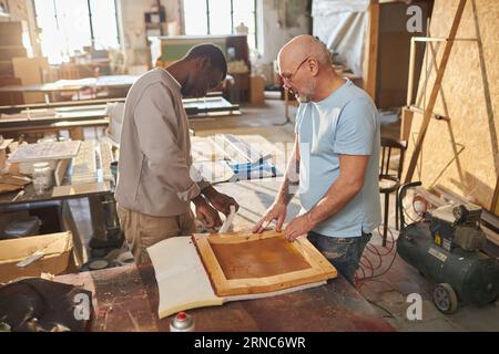 Portrait de deux charpentiers travaillant ensemble à la construction de meubles en bois dans l'atelier, espace copie Banque D'Images