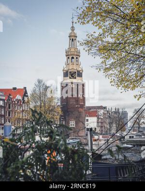 Amsterdam, pays-Bas - novembre 28 2022 : un après-midi d'automne à Amsterdam, Montelbaanstoren est majestueux sous un ciel bleu nuageux. Banque D'Images