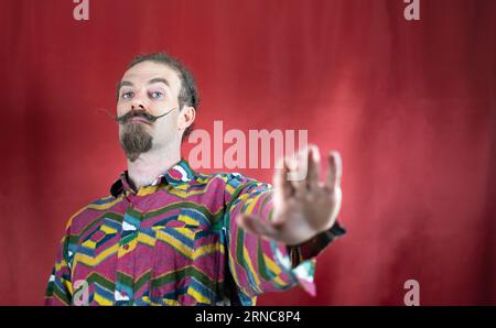 Hipster homme avec moustache disant non ou Stop et regardant la caméra avec la main ouverte Banque D'Images