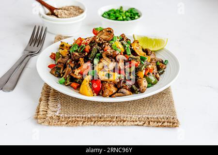 Légumes saupoudrés asiatiques avec poivrons et garnish aux champignons avec oignons verts Top Down photo sur fond blanc Banque D'Images