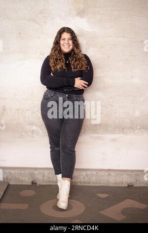 Femme souriante avec les bras croisés appuyé sur le mur au centre de recyclage Banque D'Images