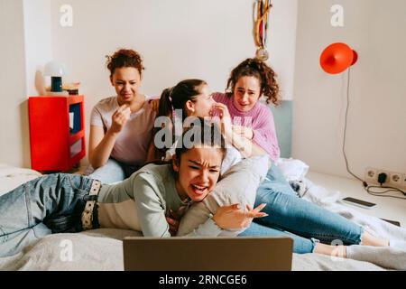 Amies femmes regardant un film ensemble à la maison Banque D'Images