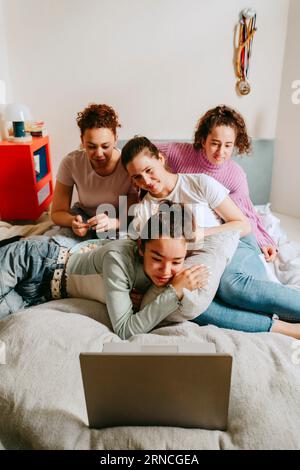 Amies femmes regardant un film ensemble sur ordinateur portable à la maison Banque D'Images