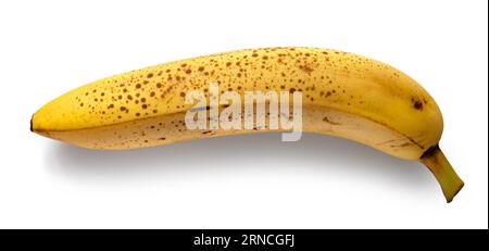 jaune banane très mûre avec des taches brunes isolées sur fond blanc, vue de dessus Banque D'Images