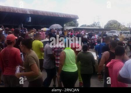 (160414) -- PASO CANOAS, 13 avril 2016 -- des personnes se tiennent près de la frontière entre le Panama et le Costa Rica, après le passage de migrants cubains et africains, à Paso Canoas, Costa Rica, le 13 avril 2016. Au moins 1 000 migrants cubains à destination des États-Unis bloqués au Panama ont violemment forcé le passage de la frontière au Costa Rica mercredi, a déclaré le ministre Costa-ricien de la sécurité Gustavo Mata. Le ministère des Affaires étrangères du Costa Rica a également publié mercredi une déclaration sur l'entrée illégale de migrants, critiquant la politique d'immigration américaine envers Cuba et notant qu'elle avait déjà traité plus de 8 000 transit spécial Banque D'Images
