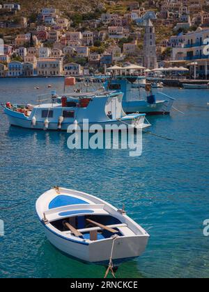 Vue sur Symi ou le port de l'île de Simi, yachts classiques, maisons sur les collines de l'île, baie de la mer Égée. Grèce vacances vacances voyages de vacances Banque D'Images