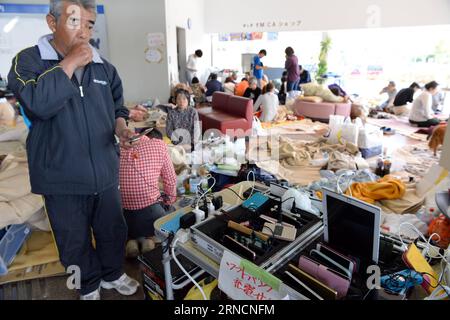 (160417) -- KUMAMOTO, April 17, 2016 -- A man recharges his cellphone at a shelter in the earthquake rocked Mashiki in Kumamoto prefecture, Japan, April 17, 2016. A powerful magnitude-7.3 earthquake struck the island of Kyushu in southwestern Japan early Saturday just a day after a sizable foreshock hit the region, with the number of fatalities now standing at 41 according to the latest figures on Sunday. ) (djj) JAPAN-KUMAMOTO-EARTHQUAKE-AFTERMATH MaxPing PUBLICATIONxNOTxINxCHN   160417 Kumamoto April 17 2016 a Man recharges His cellphone AT a Shelter in The Earthquake Rocked Mashiki in Kumam Stock Photo