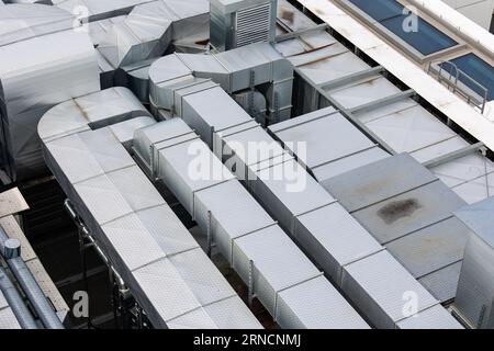 Conduits du système de ventilation et de climatisation sur le toit du bâtiment. La photo a été prise en lumière naturelle et douce. Vue d'en haut. Banque D'Images