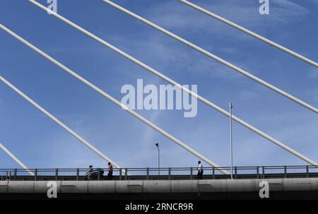 (160419) -- DAR ES SALAAM, 19 avril 2016 -- des piétons marchent sur le pont Kigamboni à Dar es Salaam, Tanzanie, le 19 avril 2016. Le nouveau pont de 135 millions de dollars américains reliant Kigamboni et Kurasini dans la capitale commerciale de l Afrique de l est, Dar es Salaam, a laissé une marque indélébile aux ingénieurs locaux. Le projet entrepris par China Railway Construction Engineering Group (CRCEG) dans le cadre d’une coentreprise avec China Railway Major Bridge Group (CRMBG) a été officiellement inauguré mardi par le président John Magufuli. Le pont de 32 mètres de large comporte six voies, trois dans chaque direction et deux Banque D'Images