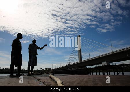 (160419) -- DAR ES SALAAM, le 19 avril 2016 -- deux bateliers regardent le pont Kigamboni Dar es Salaam, Tanzanie, le 19 avril 2016. Le nouveau pont de 135 millions de dollars américains reliant Kigamboni et Kurasini dans la capitale commerciale de l Afrique de l est, Dar es Salaam, a laissé une marque indélébile aux ingénieurs locaux. Le projet entrepris par China Railway Construction Engineering Group (CRCEG) dans le cadre d’une coentreprise avec China Railway Major Bridge Group (CRMBG) a été officiellement inauguré mardi par le président John Magufuli. Le pont de 32 mètres de large comporte six voies, trois dans chaque direction, et deux ped Banque D'Images