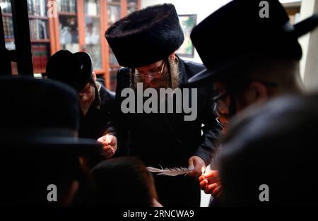 Vorbereitungen für Passah-Fest à Jérusalem, Israël (160422) -- TEL AVIV, 22 avril 2016 -- une famille juive ultra-orthodoxe prie en utilisant une bougie pour rechercher les restes de pain en préparation de la fête juive de Pâque à Rehovot, au sud de tel Aviv, Israël, le 21 avril 2016. La Pâque, qui sera marquée le 22 avril 2016, commémore l'histoire de l'Exode telle que décrite dans la Bible hébraïque en particulier dans le Livre de l'Exode, dans lequel les Israélites ont été libérés de l'esclavage en Egypte. ISRAËL-TEL AVIV-PASSOVER GilxCohenxMagen PUBLICATIONxNOTxINxCHN préparations pour Pa Banque D'Images