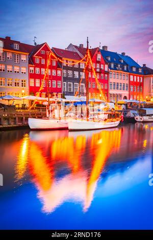 Copenhague, Danemark. Charme du canal emblématique de Nyhavn. Image de nuit colorée et reflets d'eau à couper le souffle. Banque D'Images