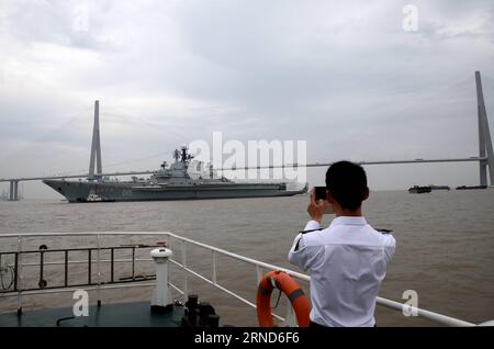 (160506) -- NANTONG, le 6 mai 2016 -- Un travailleur local de la sécurité maritime prend une photo du porte-avions Minsk alors qu'il passe le pont Sutong à Nantong, dans la province du Jiangsu, dans l'est de la Chine, le 5 mai 2016. Minsk sera construit comme un nouveau parc à thème à Nantong. Minsk a servi dans la marine soviétique, et plus tard dans la marine russe, de 1978 à 1994. De 2000 à 2016, il a été un parc à thème connu sous le nom de Minsk World dans le sud de la Chine s Shenzhen.) (lfj) CHINA-JIANGSU-NANTONG-AIRCRAFT CARRIER MINSK (CN) WangxZhenyu PUBLICATIONxNOTxINxCHN 160506 Nantong Mai 6 2016 un travailleur local de la sécurité maritime prend une photo du porte-avions min Banque D'Images