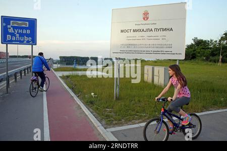 (160531) -- BELGRADE, May 31, 2016 -- A girl and her father ride bicycles on a bicycle track at Pupin bridge in Belgrade, Serbia, on May 23. 2016. The Bridge, named after Serbian scientist and inventor Mihajlo Pupin, was opened by Premier of the People s Republic of China Li Keqiang and his Serbian counterpart Aleksandar Vucic on December 18, 2014. As the second bridge over the Danube river in Belgrade, it has ended the history that for 70 years there was only one bridge in Belgrade over Danube. Connecting Zemun on the south of Danube and Borca on the north, the bridge has shortened the travel Stock Photo