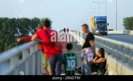 (160531) -- BELGRADE, May 31, 2016 -- Photo taken on May 23, 2016 shows people enjoying sunset at Pupin bridge in Belgrade, Serbia. The Bridge, named after Serbian scientist and inventor Mihajlo Pupin, was opened by Premier of the People s Republic of China Li Keqiang and his Serbian counterpart Aleksandar Vucic on December 18, 2014. As the second bridge over the Danube river in Belgrade, it has ended the history that for 70 years there was only one bridge in Belgrade over Danube. Connecting Zemun on the south of Danube and Borca on the north, the bridge has shortened the travel time from more Stock Photo