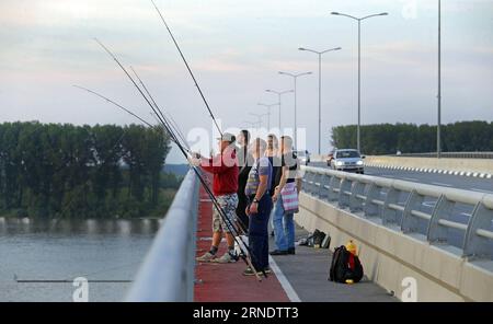 (160531) -- BELGRADE, May 31, 2016 -- People fish at the Pupin bridge in Belgrade, Serbia, on May 23. 2016. The Bridge, named after Serbian scientist and inventor Mihajlo Pupin, was opened by Premier of the People s Republic of China Li Keqiang and his Serbian counterpart Aleksandar Vucic on December 18, 2014. As the second bridge over the Danube river in Belgrade, it has ended the history that for 70 years there was only one bridge in Belgrade over Danube. Connecting Zemun on the south of Danube and Borca on the north, the bridge has shortened the travel time from more than an hour to just 10 Stock Photo