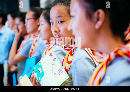 HAIKOU, May 31, 2016 -- Children experience the jobs of flight attendants on an airplane of Hainan Airlines from Beijing, capital of China, to Haikou, capital of south China s Hainan Province, May 31, 2016. These children came from quake-battered Yushu Tibetan Autonomous Prefecture in northwest China s Qinghai Province. The catastrophic earthquake in 2010 left nearly 3,000 people dead or missing. Now 10 of the Yushu orphans aided by the China Charities Aid Foundation for Children were invited to take part in the experiencing activity to celebrate the Children s Day. Children realized their dre Stock Photo