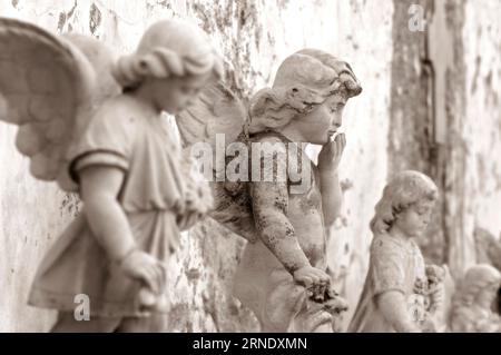 Pierre tombale au vieux cimetière, Figurine d'un ange ailé soufflant un baiser Banque D'Images