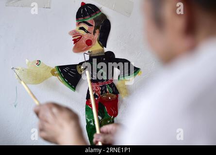 (160606) -- TIANJIN, 5 juin 2016 -- l'artiste marionnettiste de l'ombre Zhang Kui joue des marionnettes de l'ombre à la maison à Tianjin, dans le nord de la Chine, le 5 juin 2016. Zhang Kui, né en 1937, est aujourd'hui héritier de marionnettes d'ombre. Il a dépendu des marionnettes de l'ombre pour vivre pendant 68 ans depuis son enfance. Mon père avait 38 boîtes d'ombre, mon frère a joué et j'ai sculpté les marionnettes d'ombre, a déclaré l'héritier quand il s'est souvenu de son enfance. De nos jours, moins de gens aiment la performance de marionnette d'ombre. Zhang Kui avait autrefois deux apprentis, mais les deux ont finalement abandonné et ont réalisé d'autres busin rentables Banque D'Images