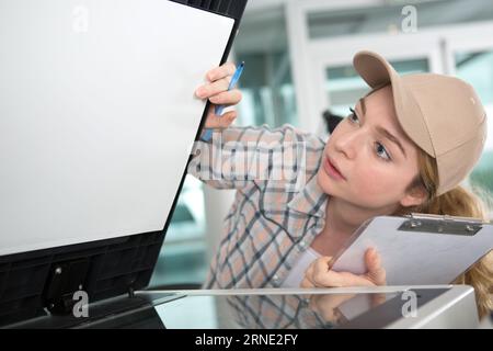 ingénieur féminin professionnel travaillant à la vérification d'une impression 3d. Banque D'Images