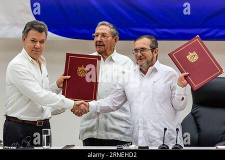 Bilder des Tages Kolumbien: FARC und Regierung schließen Waffenstillstand (160623) -- HAVANA, June 23, 2016 -- Colombian President Juan Manuel Santos (L) and Timoleon Jimenez (R), the top leader of the Revolutionary Armed Forces of Colombia (FARC), exchange pacts while Cuban President Raul Castro witnesses in Havana, capital of Cuba, June 23, 2016. The Colombian government and the FARC guerrilla group signed a pact on a definitive bilateral ceasefire, marking a major step towards ending a half-century conflict. Colombia s conflict has killed more than 220,000 people and displaced millions sinc Stock Photo