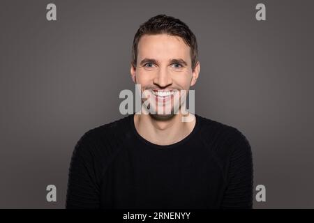 humoristique homme heureux riant caméra d'intro avec la bouche ouverte montrant ses dents tout en réagissant à la situation drôle Banque D'Images