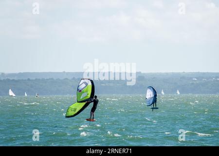 Hill Head Angleterre - août 20 2023 : windsurfeurs sur une mer agitée avec l'île de Wight Hampshire en arrière-plan Banque D'Images