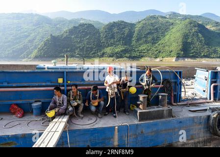 (160725) -- CHONGQING, 25 juillet 2016 -- les travailleurs discutent entre eux avant de mettre en œuvre une opération d'élimination des risques sur un escarpement des zones des trois Gorges à Chongqing, dans le sud-ouest de la Chine, le 25 juillet 2016. Ces ouvriers surnommés araignée-homme ou araignée-femme des trois Gorges renforcent les escarpements de la région pour prévenir les catastrophes géologiques. )(MCG) CHINA-CHONGQING-THREE GORGES-SPIDER-MAN (CN) LiuxChan PUBLICATIONxNOTxINxCHN 160725 Chongqing juillet 25 2016 les travailleurs discutent entre eux avant de mettre en œuvre une opération d'élimination des risques SUR l'escarpement des zones des trois Gorges à Chongqing Sou Banque D'Images