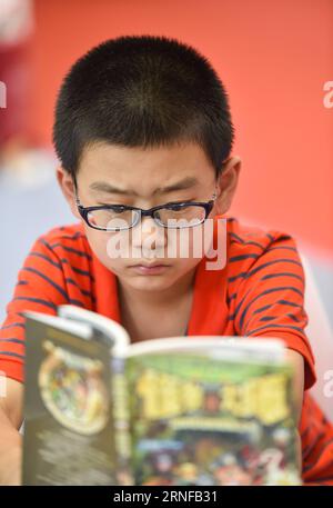 BAOTOU, le 28 juillet 2016 -- Un garçon lit à la 26e exposition nationale du commerce du livre à Baotou, dans la région autonome de Mongolie intérieure du nord de la Chine, le 28 juillet 2016. L'expo avec quelque 230 000 publications s'est ouverte jeudi. ) (Cxy) CHINA-BAOTOU-BOOK TRADING EXPO (CN) LianxZhen PUBLICATIONxNOTxINxCHN Baotou juillet 28 2016 un garçon lit À la 26e exposition nationale de trading de livres à Baotou dans la région autonome de Mongolie intérieure du nord de la Chine juillet 28 2016 l'exposition avec quelque 230 000 publications a ouvert ici jeudi Cxy China Baotou Book Trading EXPO CN LianxZhen PUBLICATIONxNOTxINxCHN Banque D'Images