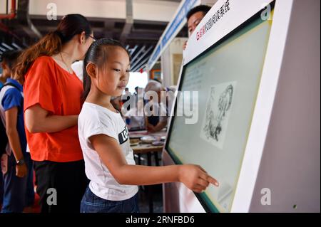 Buchmesse à Baotou, Chine (160729) -- BAOTOU, le 29 juillet 2016 -- une fille lit à travers un écran électronique lors de la 26e exposition nationale du livre à Baotou, dans la région autonome de Mongolie intérieure du nord de la Chine, le 29 juillet 2016. L'expo de trois jours, qui a débuté ici jeudi, a attiré de nombreux exposants utilisant de nouvelles technologies comme la réalité augmentée et la réalité virtuelle. )(wjq) CHINA-INNER MONGOLIA-BOOK EXPO (CN) LianxZhen PUBLICATIONxNOTxINxCHN Foire du livre à Baotou Chine 160729 Baotou juillet 29 2016 une fille lit à travers à l'écran électronique pendant la 26e exposition nationale de livre à Baotou Nord Chine S Inner Mo Banque D'Images