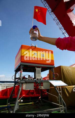 (160812) -- SANYA, 12 août 2016 -- Un chercheur montre un échantillon d'eau en haute mer et de l'équipement sur le navire-mère submersible de haute mer de Chine, Tansuo-1, à Sanya, dans la province de Hainan du sud de la Chine, le 12 août 2016. Le Tansuo-1 est retourné à Sanya vendredi après avoir terminé son voyage inaugural réussi dans la tranchée des Mariannes. Le navire-mère transportait 60 chercheurs et membres d'équipage ainsi qu'un submersible autonome télécommandé de 10 000 mètres, un sismomètre de fond océanique de 9 000 mètres et d'autres dispositifs fabriqués localement. Il a quitté Sanya le 22 juin pour l'expédition Mariana Trench. (WYL) CHINE-SANYA-DEEP-SEA SUBMER Banque D'Images