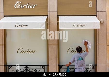 Un homme nettoie la vitrine d'un magasin Cartier à Monte Carlo, Monaco, France Banque D'Images