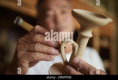 (160819) -- HUILI, 19 août 2016 -- Han Jinfu, héritier de la technique de la poterie vernissée verte, fixe une base de poterie dans le comté de Huili de la préfecture autonome de Liangshan Yi, province du Sichuan au sud-ouest de la Chine, 18 août 2016. La poterie vernie de Huili jouit d'une grande renommée au Sichuan. Il est nommé comme poterie verte parce qu'il contient de la malachite qui devient verte après avoir brûlé à haute température. Il a été inscrit au patrimoine culturel immatériel du Sichuan en 2009. (mp) CHINA-SICHUAN-HUILI-POTTERY (CN) XuexYubin PUBLICATIONxNOTxINxCHN 160819 Huili août 19 2016 Han Jinfu héritier de la glaçure verte Banque D'Images