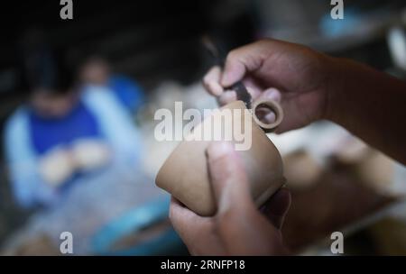 (160819) -- HUILI, 19 août 2016 -- Un personnel de travail fabrique une base de poterie vernissée verte dans le comté de Huili de la préfecture autonome de Liangshan Yi, province du Sichuan au sud-ouest de la Chine, 18 août 2016. La poterie vernie de Huili jouit d'une grande renommée au Sichuan. Il est nommé comme poterie verte parce qu'il contient de la malachite qui devient verte après avoir brûlé à haute température. Il a été inscrit au patrimoine culturel immatériel du Sichuan en 2009. (mp) CHINA-SICHUAN-HUILI-POTTERY (CN) XuexYubin PUBLICATIONxNOTxINxCHN 160819 Huili août 19 2016 une équipe de travail fabrique une base de poterie verte émaillée à Hu Banque D'Images