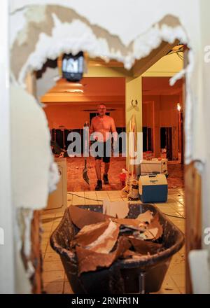 (160821) -- BATON ROUGE (USA), Aug. 20, 2016 -- A man removes the damaged wall of his house in Baton Rouge, the United States, Aug. 20, 2016. Severe flooding caused by heavy rain hit the southern part of the U.S. state of Louisiana. According to local media, up to 13 people have been killed and thousands of residents have been forced to leave their homes. ) (zjy) U.S.-BATON ROUGE-FLOOD-AFTERMATH ZhangxChaoqun PUBLICATIONxNOTxINxCHN   160821 Baton Rouge USA Aug 20 2016 a Man removes The damaged Wall of His House in Baton Rouge The United States Aug 20 2016 severe flooding CAUSED by Heavy Rain H Stock Photo