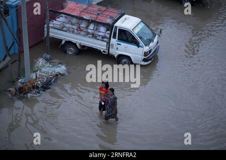 (160821) -- MANDALAY (MYANMAR), 21 août 2016 -- des résidents se promenaient dans une zone inondée à Mandalay, Myanmar, 21 août 2016. Les inondations, qui ont commencé à la mi-juillet, continuent de frapper les régions de Bago, Ayeyawaddy et Yangon, bien que certaines régions comme l'État de Kachin et les régions de Sagaing, Mandalay et Magway aient fermé leurs camps de secours à mesure que les eaux d'inondation se sont dissipées, a déclaré le ministère de la protection sociale, des secours et de la réinstallation.) (wtc) MYANMAR-MANDALAY-FLOOD PhyoxGyi PUBLICATIONxNOTxINxCHN 160821 Mandalay Myanmar août 21 2016 résidents Calf à travers une zone inondée à Mandalay Myanmar août 21 2016 Banque D'Images